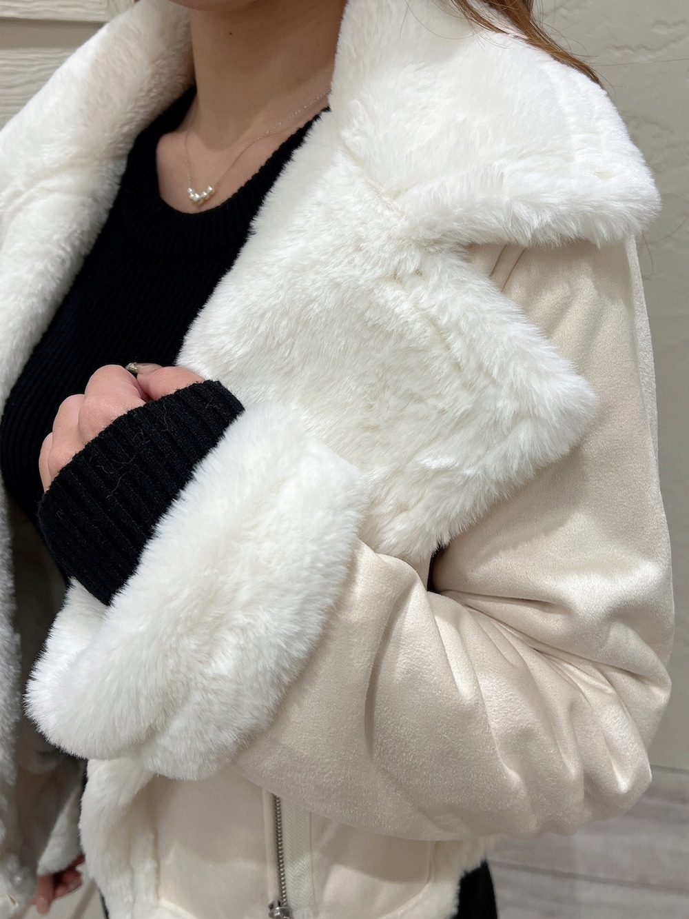 ブラック系のワンピース、ブラック系のブーツ、ホワイト系のブルゾンを着用したレディースの秋コーディネートの7枚目の写真