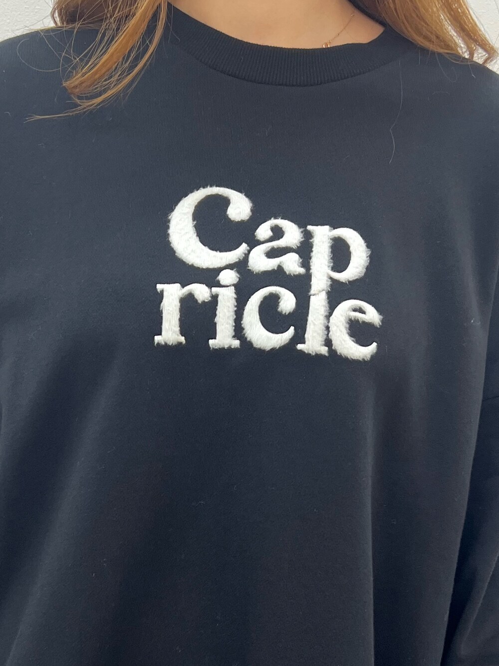 ブラック系のスウェット、グリーン系のハンドバッグ、ブラック系のブーツを着用したレディースの夏コーディネートの5枚目の写真