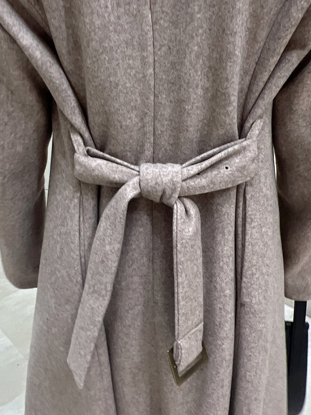 ブラウン系のチェスターコート、ブラウン系のブーツ、ブラック系のニット/セーターを着用したレディースの冬コーディネートの6枚目の写真