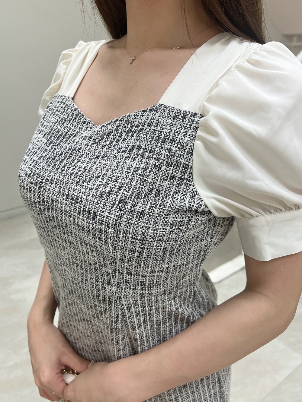 ブラック系のワンピース、ホワイト系のハンドバッグ、ホワイト系のサンダルを着用したレディースの春コーディネートの5枚目の写真