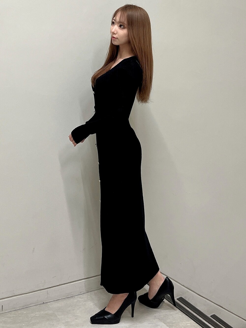 ブラック系のワンピース、ブラック系のパンプスを着用したレディースの冬コーディネートの3枚目の写真