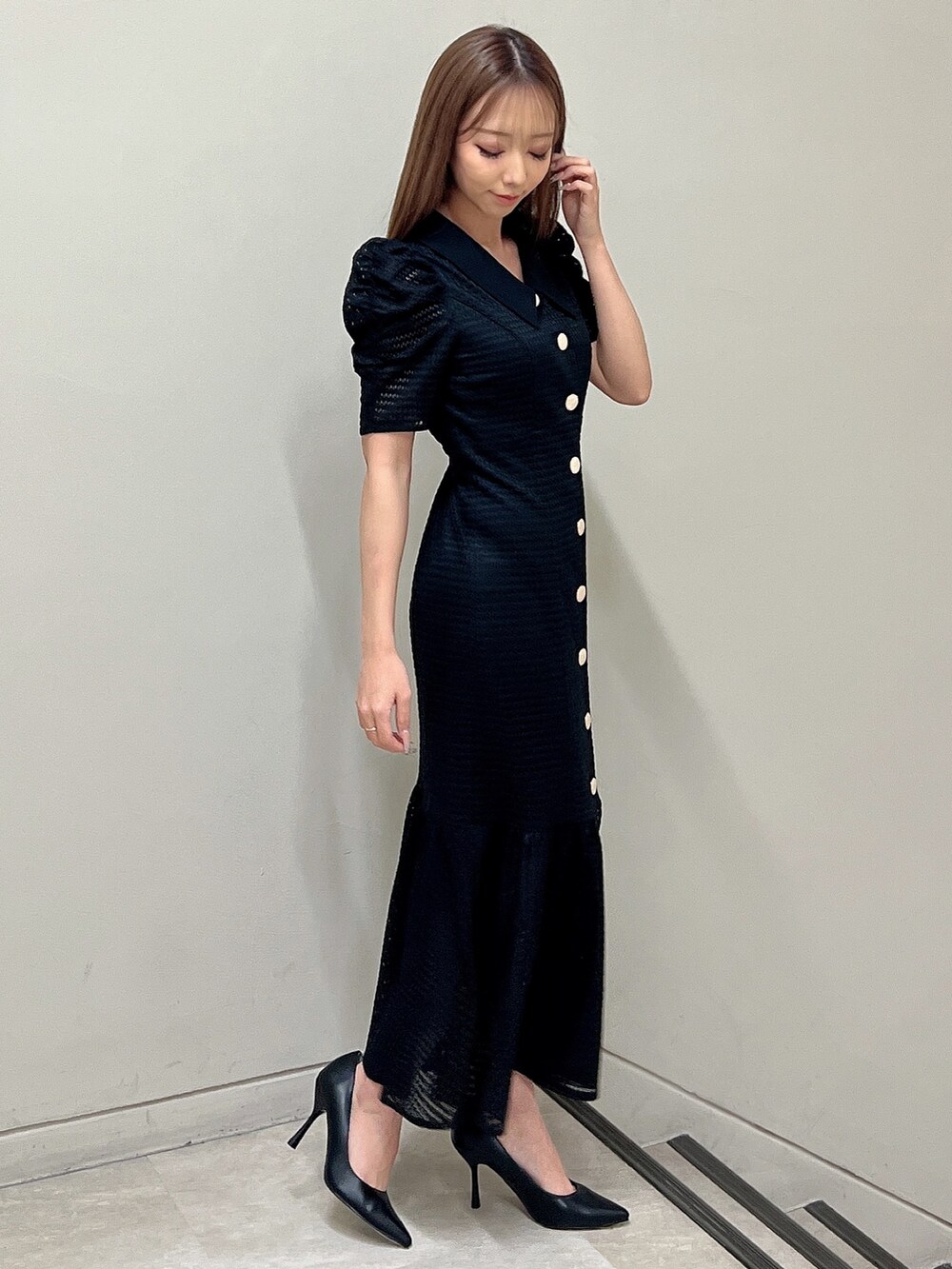 ブラック系のワンピース、ブラック系のパンプスを着用したレディースの春コーディネートの2枚目の写真