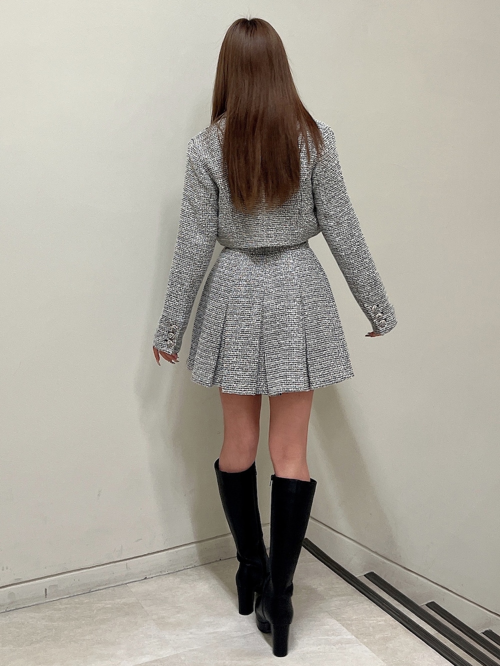 ブラック系のスカート、ブラック系のニット/セーター、ブラック系のテーラードジャケットを着用したレディースの春コーディネートの4枚目の写真