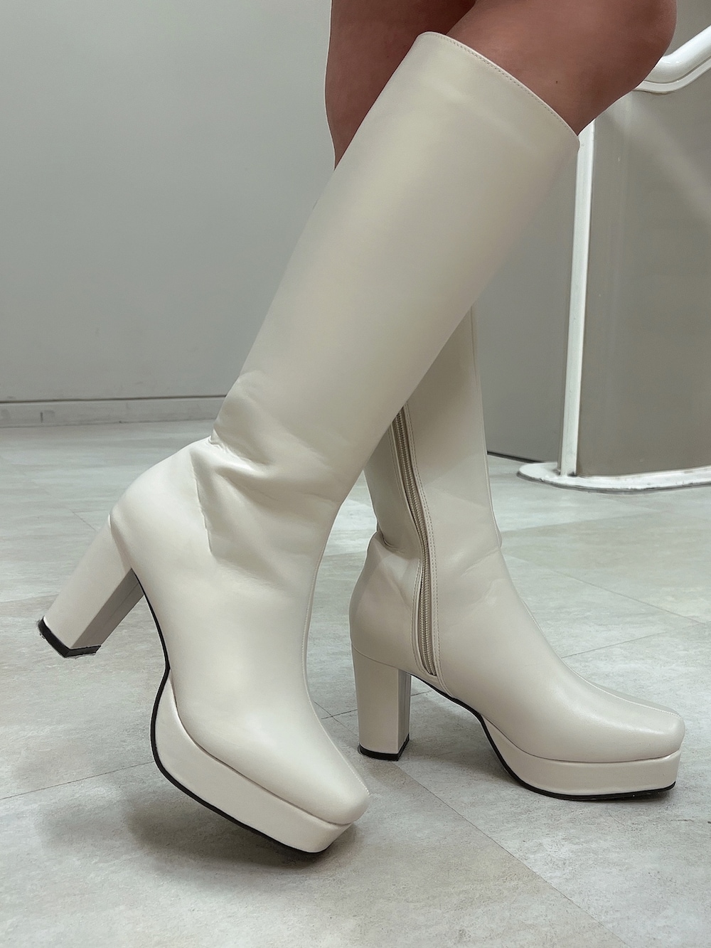 ホワイト系のワンピース、ピンク系のハンドバッグ、ホワイト系のブーツを着用したレディースの冬コーディネートの7枚目の写真