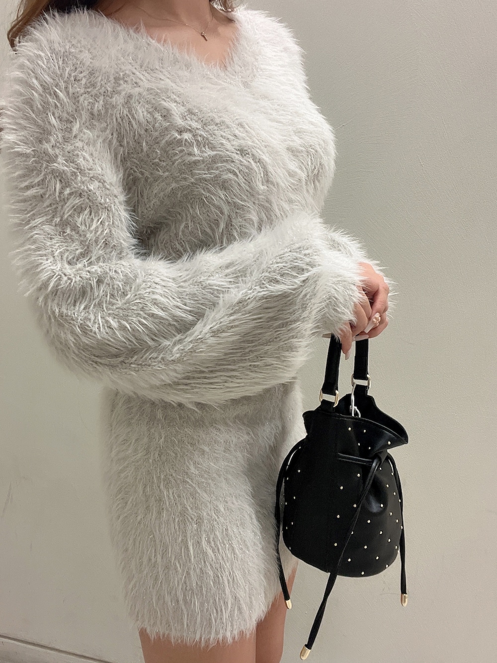 グレー系のワンピース、ブラック系のハンドバッグ、ブラック系のブーツを着用したレディースの秋コーディネートの8枚目の写真