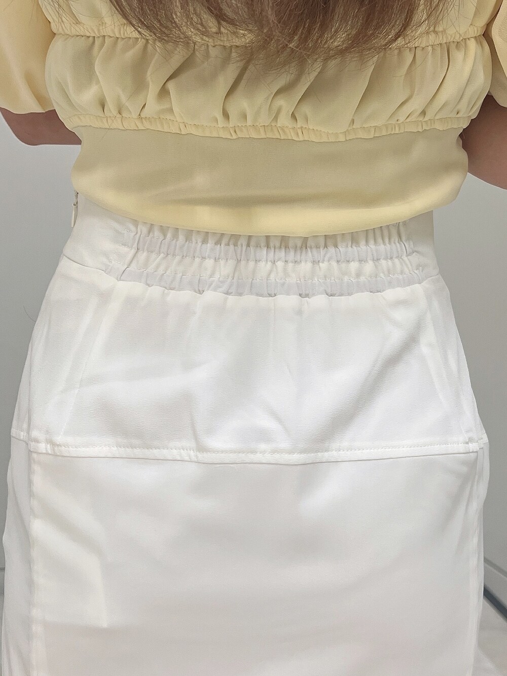 イエロー系のシャツ/ブラウス、ホワイト系のスカート、イエロー系のハンドバッグを着用したレディースの春コーディネートの6枚目の写真