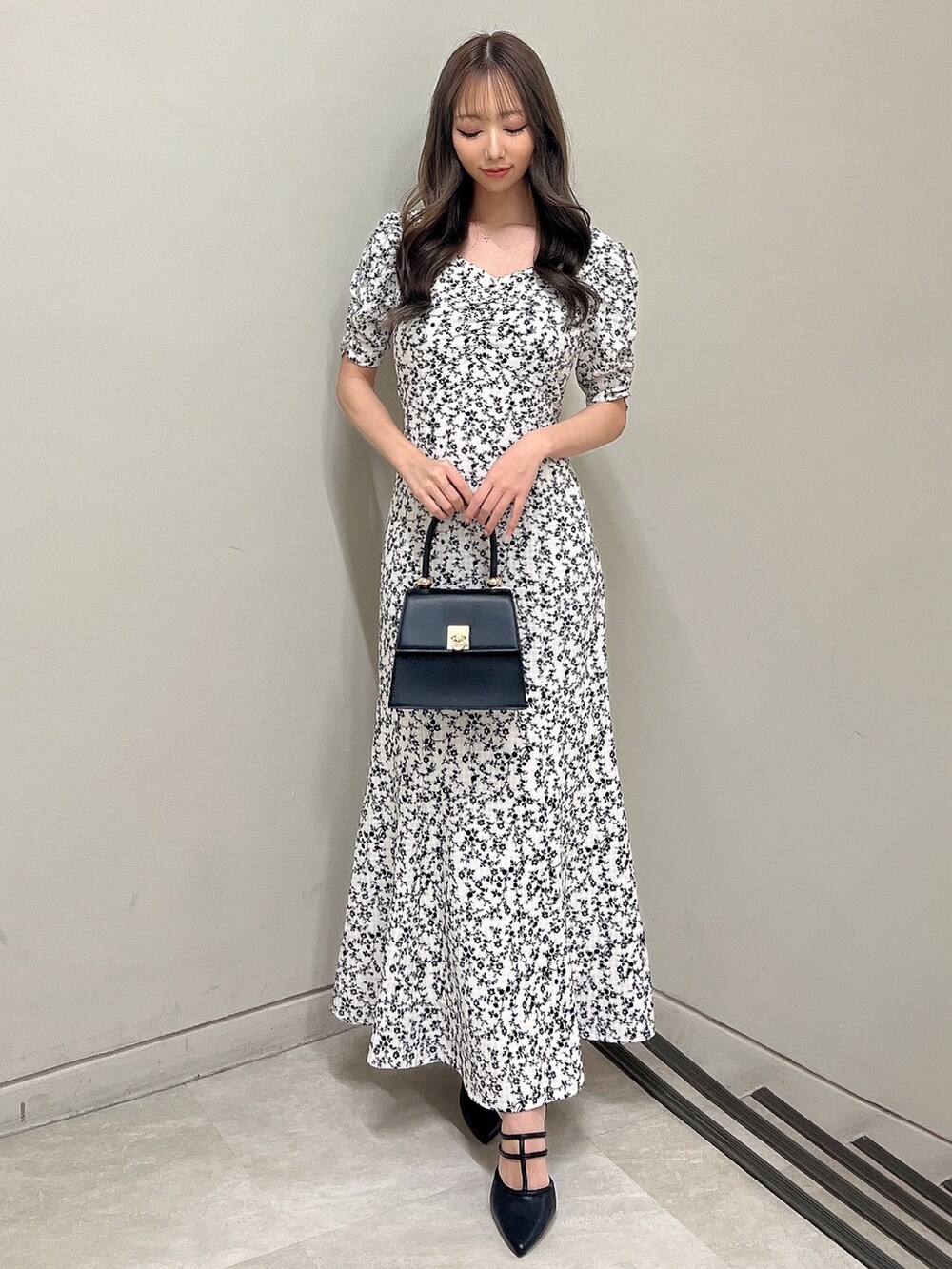 その他のワンピース、ブラック系のパンプス、ブラック系のハンドバッグを着用したレディースの春コーディネートの2枚目の写真