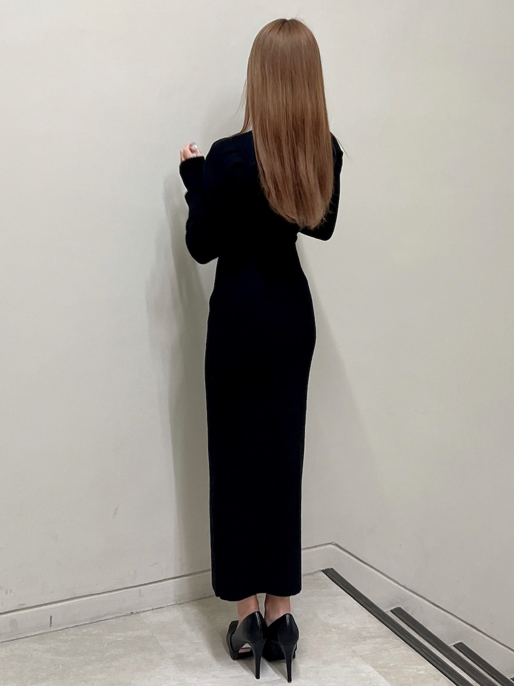 ブラック系のワンピース、ブラック系のパンプスを着用したレディースの冬コーディネートの4枚目の写真