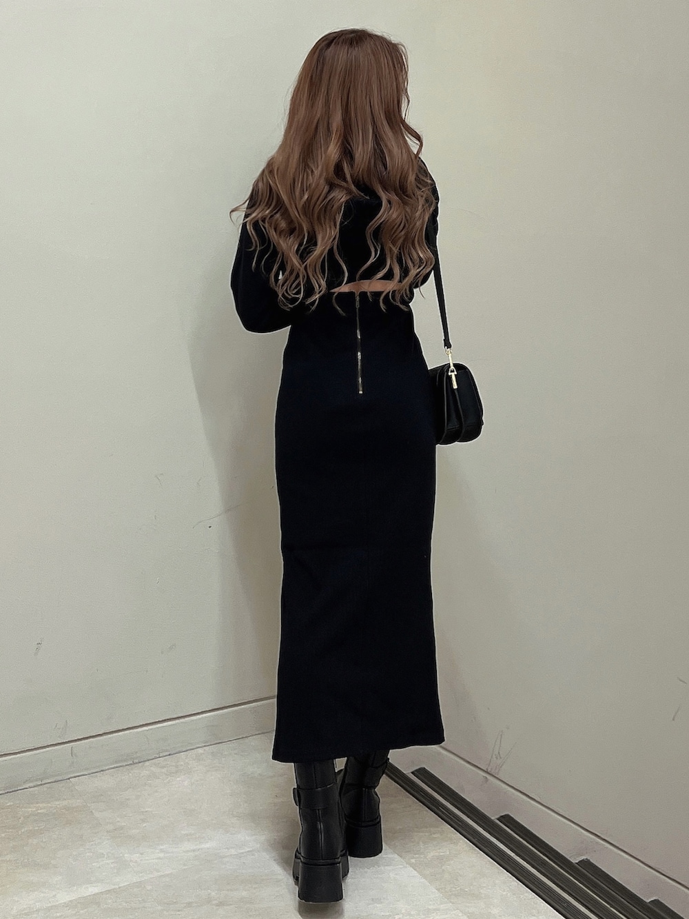 ブラック系のブーツ、ブラック系のショルダーバッグ、ブラック系のワンピースを着用したレディースの秋コーディネートの5枚目の写真