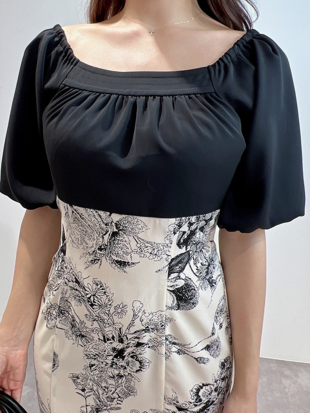 ブラック系のワンピース、ブラック系のサンダル、ブラック系のハンドバッグを着用したレディースの冬コーディネートの5枚目の写真