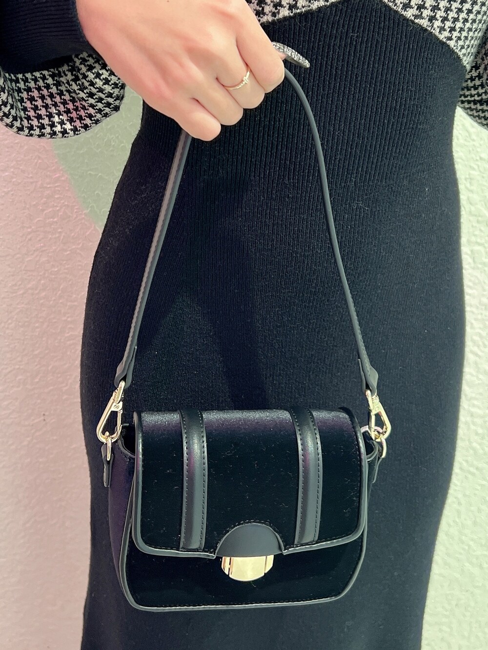 ブラック系のワンピース、ブラック系のパンプス、ブラック系のショルダーバッグを着用したレディースの冬コーディネートの5枚目の写真