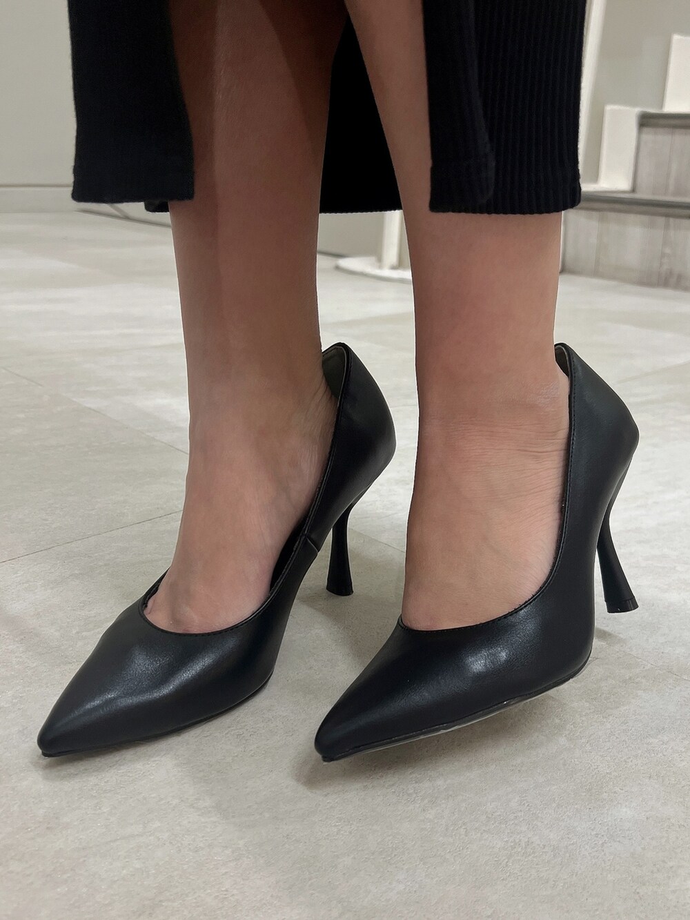 ブラック系のワンピース、ブラック系のライダースジャケット、ブラック系のパンプスを着用したレディースの冬コーディネートの9枚目の写真