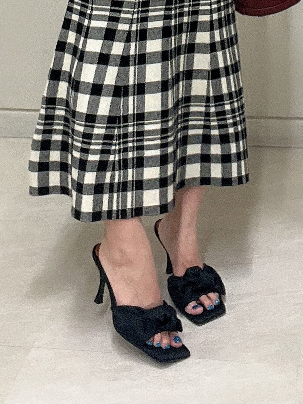 レッド系のショルダーバッグ、ブラック系のワンピース、ブラック系のサンダルを着用したレディースの夏コーディネートの7枚目の写真