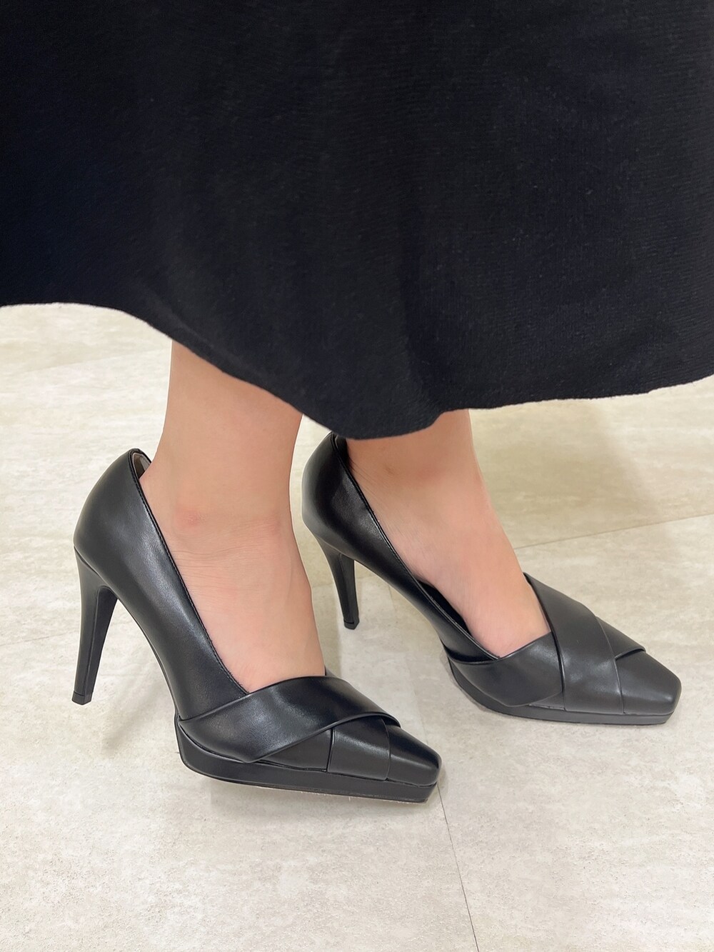 ブラック系のワンピース、ブラック系のショルダーバッグ、ブラック系のパンプスを着用したレディースの冬コーディネートの8枚目の写真