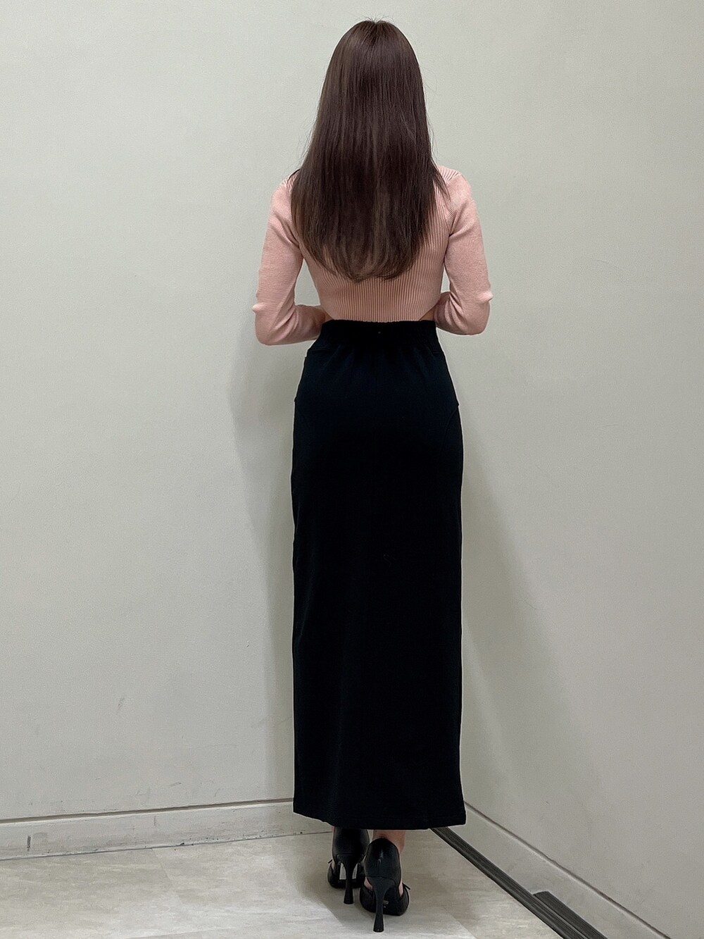 ブラック系のスカート、ピンク系のニット/セーター、ブラック系のパンプスを着用したレディースの冬コーディネートの5枚目の写真
