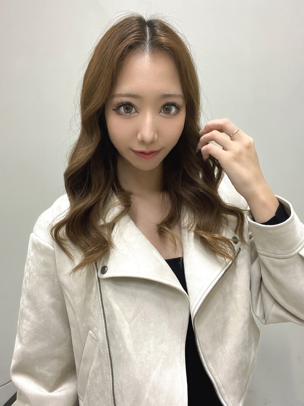 ベージュ系のライダースジャケット、ブラック系のワンピース、ベージュ系のサンダルを着用したレディースの秋コーディネートの5枚目の写真