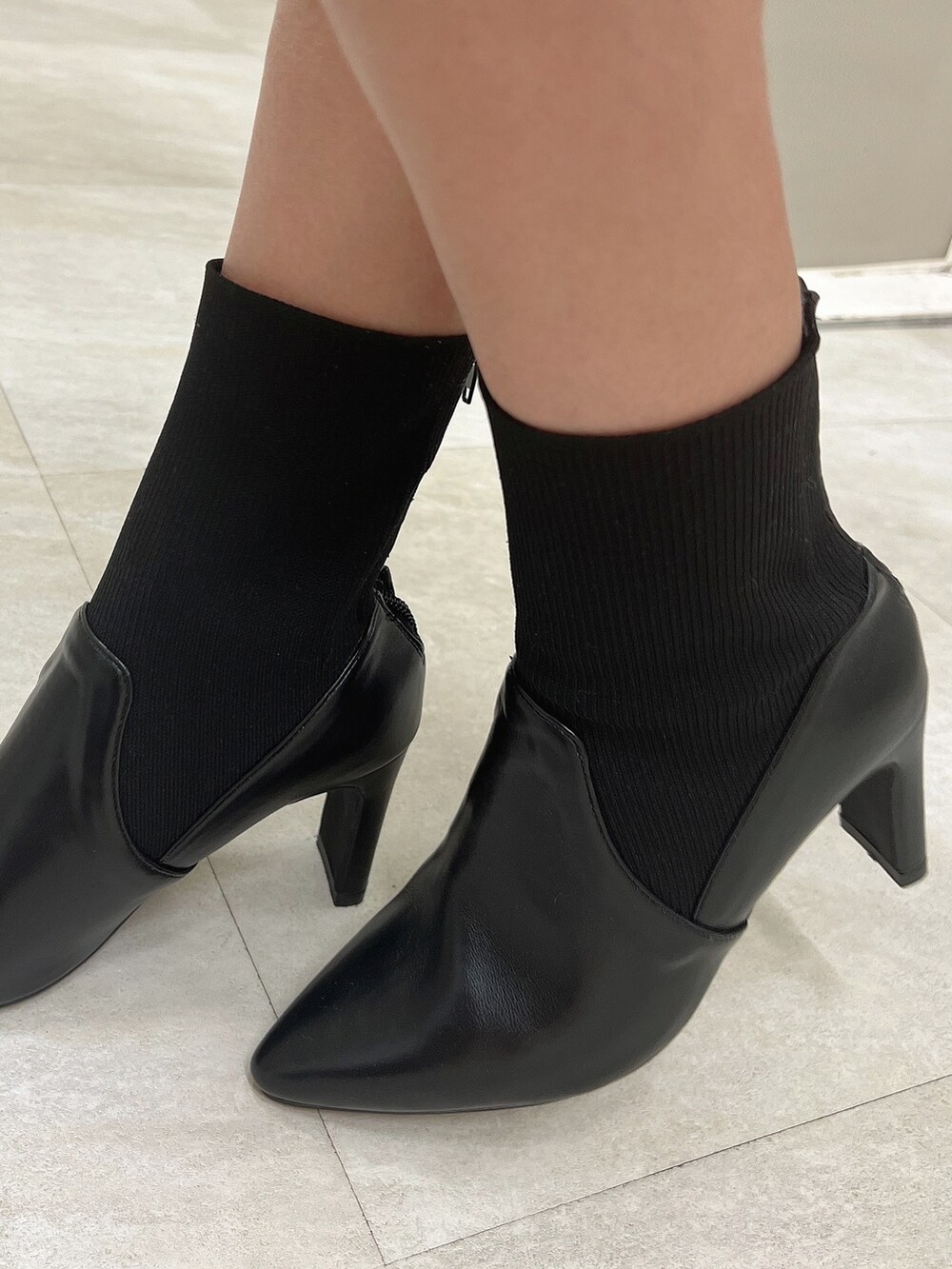 ブラック系のショルダーバッグ、ブラック系のブーツ、ベージュ系のニット/セーターを着用したレディースの冬コーディネートの8枚目の写真