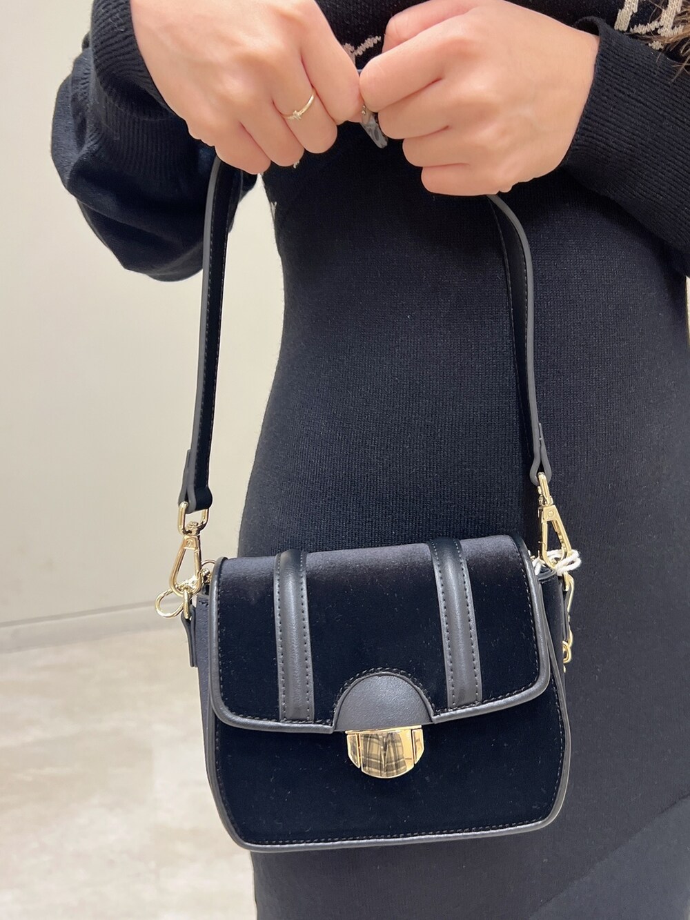 ブラック系のワンピース、ブラック系のショルダーバッグ、ブラック系のパンプスを着用したレディースの冬コーディネートの7枚目の写真