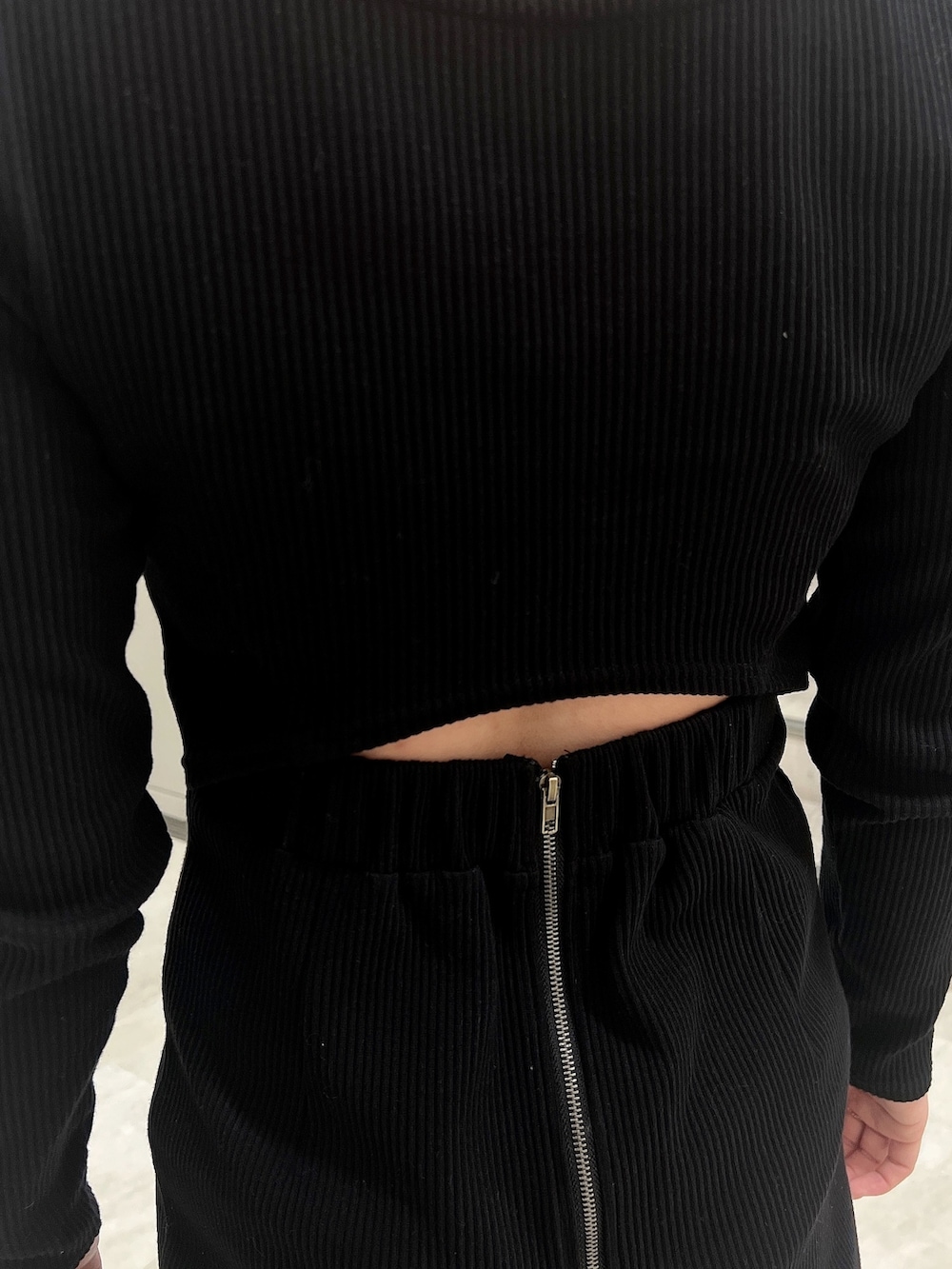 ブラック系のワンピース、ブラック系のライダースジャケット、ブラック系のパンプスを着用したレディースの冬コーディネートの6枚目の写真