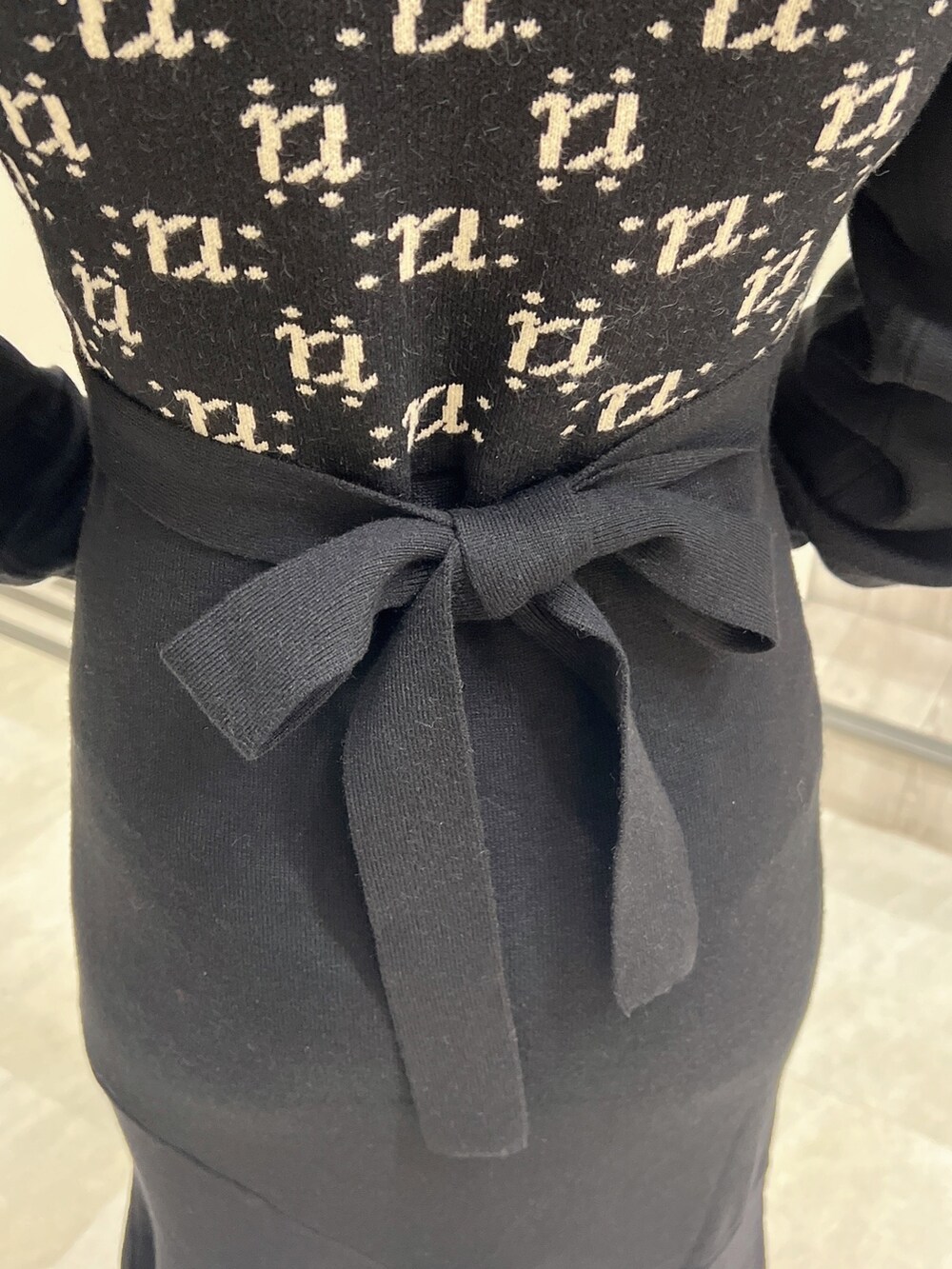 ブラック系のワンピース、ブラック系のショルダーバッグ、ブラック系のパンプスを着用したレディースの冬コーディネートの6枚目の写真