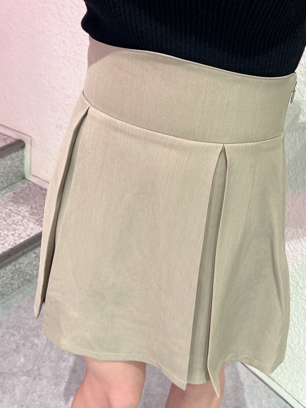 ブラック系のニット/セーター、ブラック系のハンドバッグ、ベージュ系のスカートを着用したレディースの冬コーディネートの8枚目の写真