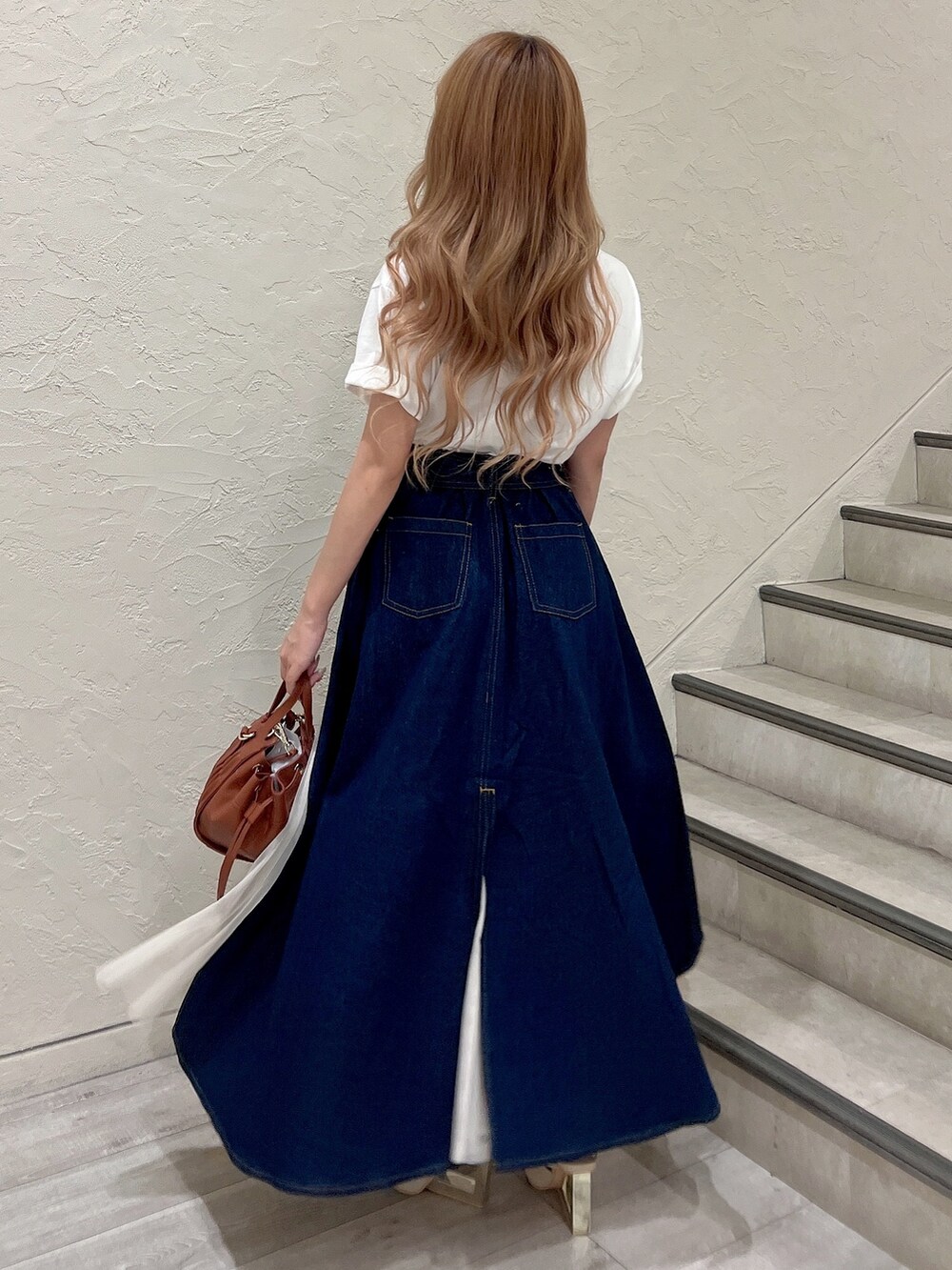 ホワイト系のTシャツ/カットソー、ブラウン系のハンドバッグ、ホワイト系のサンダルを着用したレディースの夏コーディネートの5枚目の写真