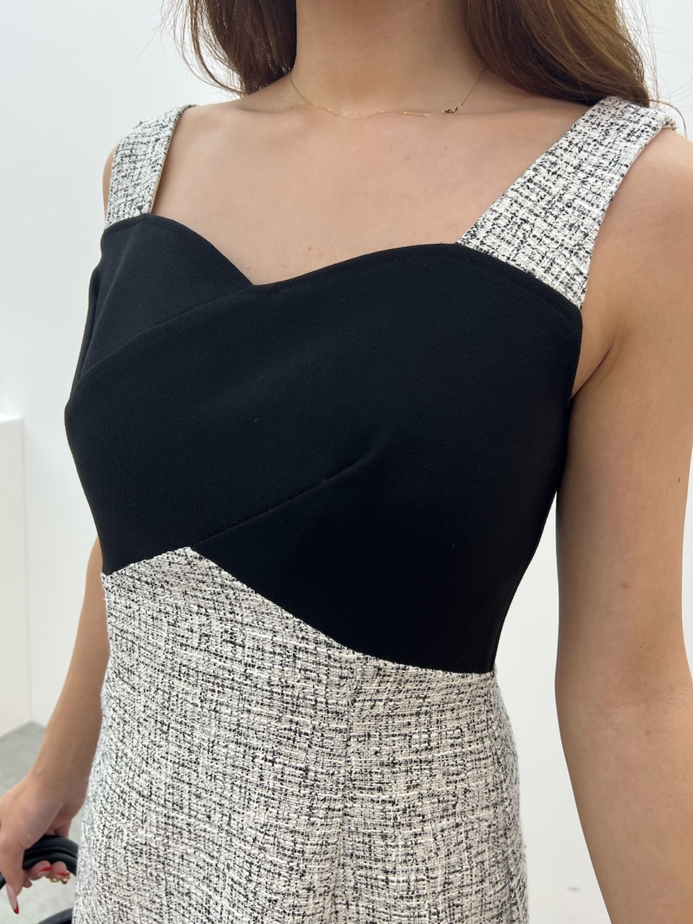 ブラック系のパンプス、ブラック系のハンドバッグ、ブラック系のワンピースを着用したレディースの夏コーディネートの6枚目の写真