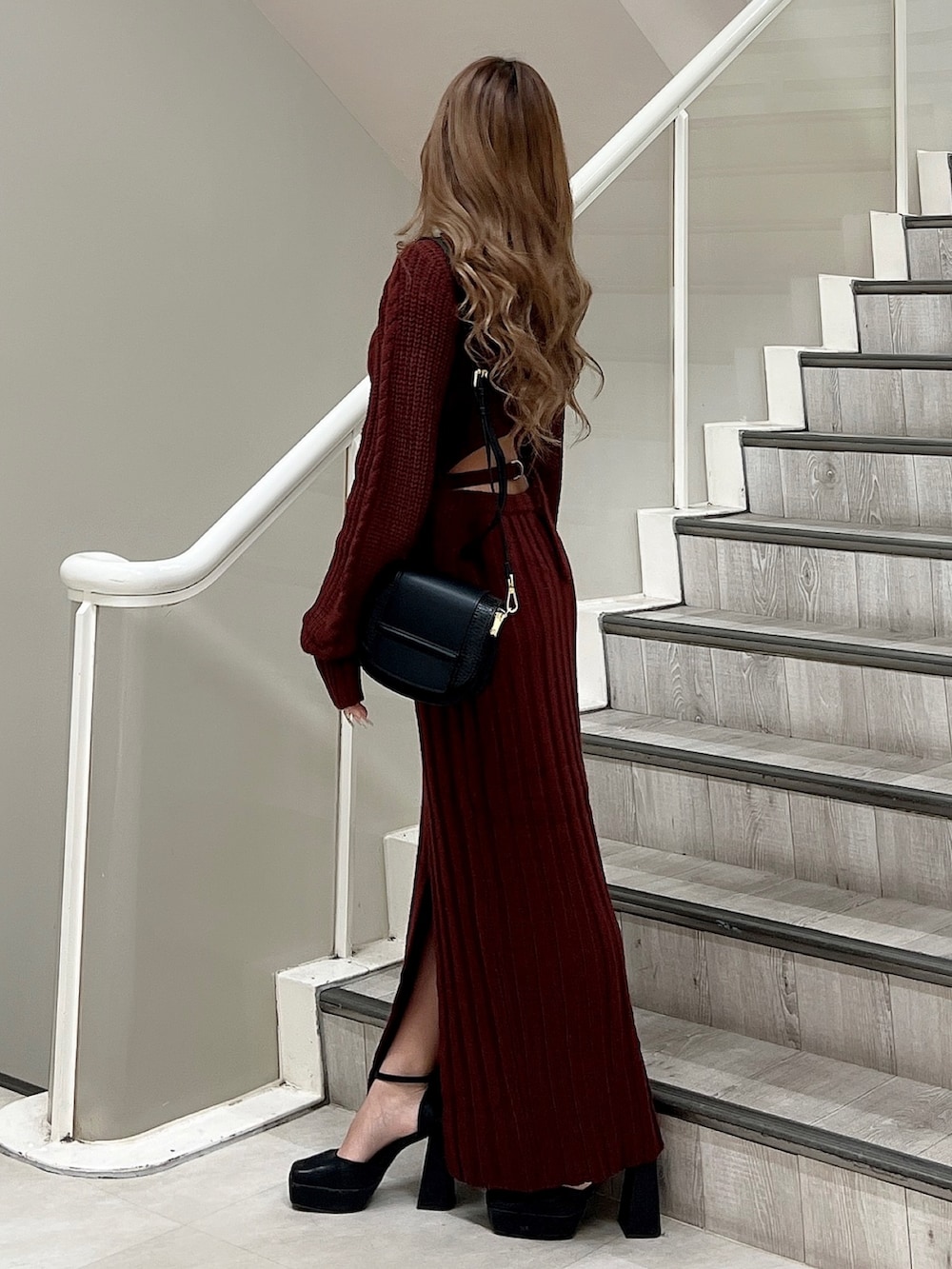 ブラック系のパンプス、ブラック系のショルダーバッグ、レッド系のワンピースを着用したレディースの秋コーディネートの3枚目の写真