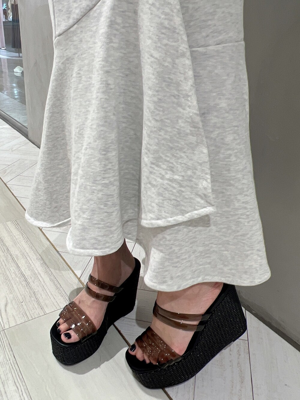 グレー系のTシャツ/カットソー、グレー系のスカート、ブラック系のサンダルを着用したレディースの春コーディネートの8枚目の写真