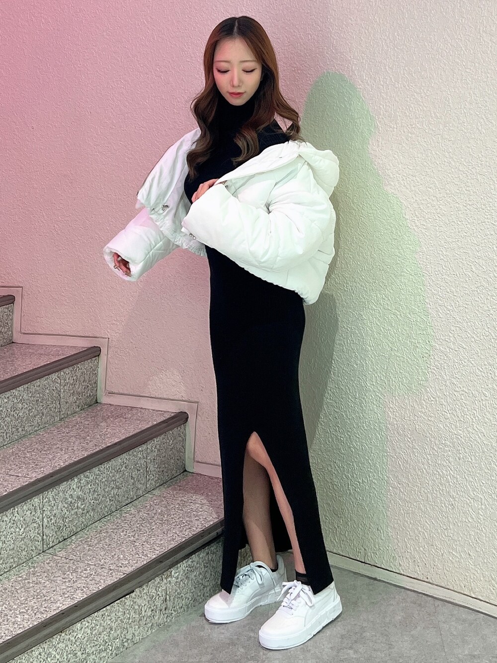 ブラック系のワンピース、ホワイト系のブルゾン、ホワイト系のスニーカーを着用したレディースの冬コーディネートの2枚目の写真