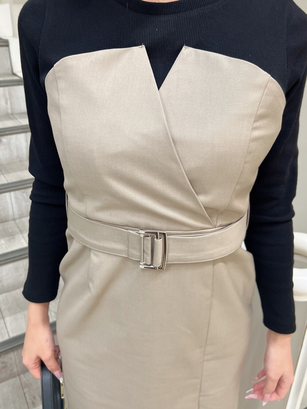 ベージュ系のワンピース、ブラック系のブーツ、ブラック系のハンドバッグを着用したレディースの冬コーディネートの5枚目の写真