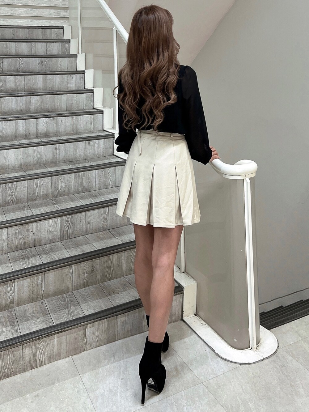 ブラック系のシャツ/ブラウス、ホワイト系のスカート、ブラック系のブーツを着用したレディースの秋コーディネートの4枚目の写真