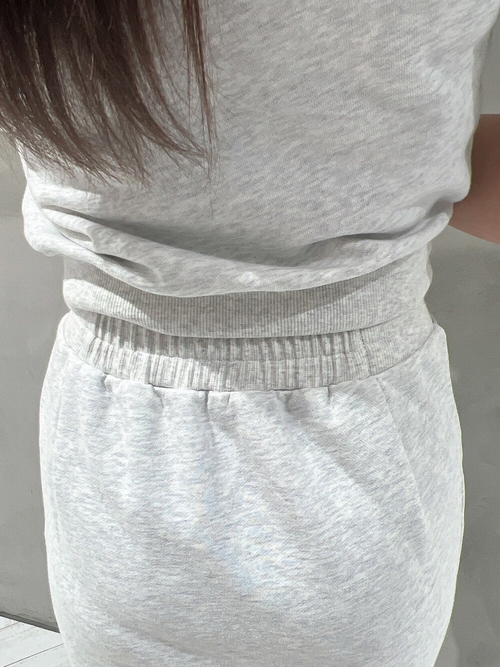 グレー系のTシャツ/カットソー、グレー系のスカート、ブラック系のサンダルを着用したレディースの春コーディネートの6枚目の写真