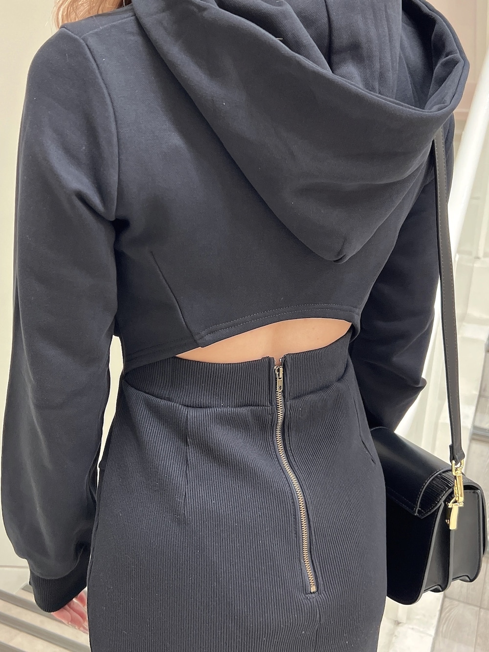 ブラック系のブーツ、ブラック系のショルダーバッグ、ブラック系のワンピースを着用したレディースの秋コーディネートの6枚目の写真