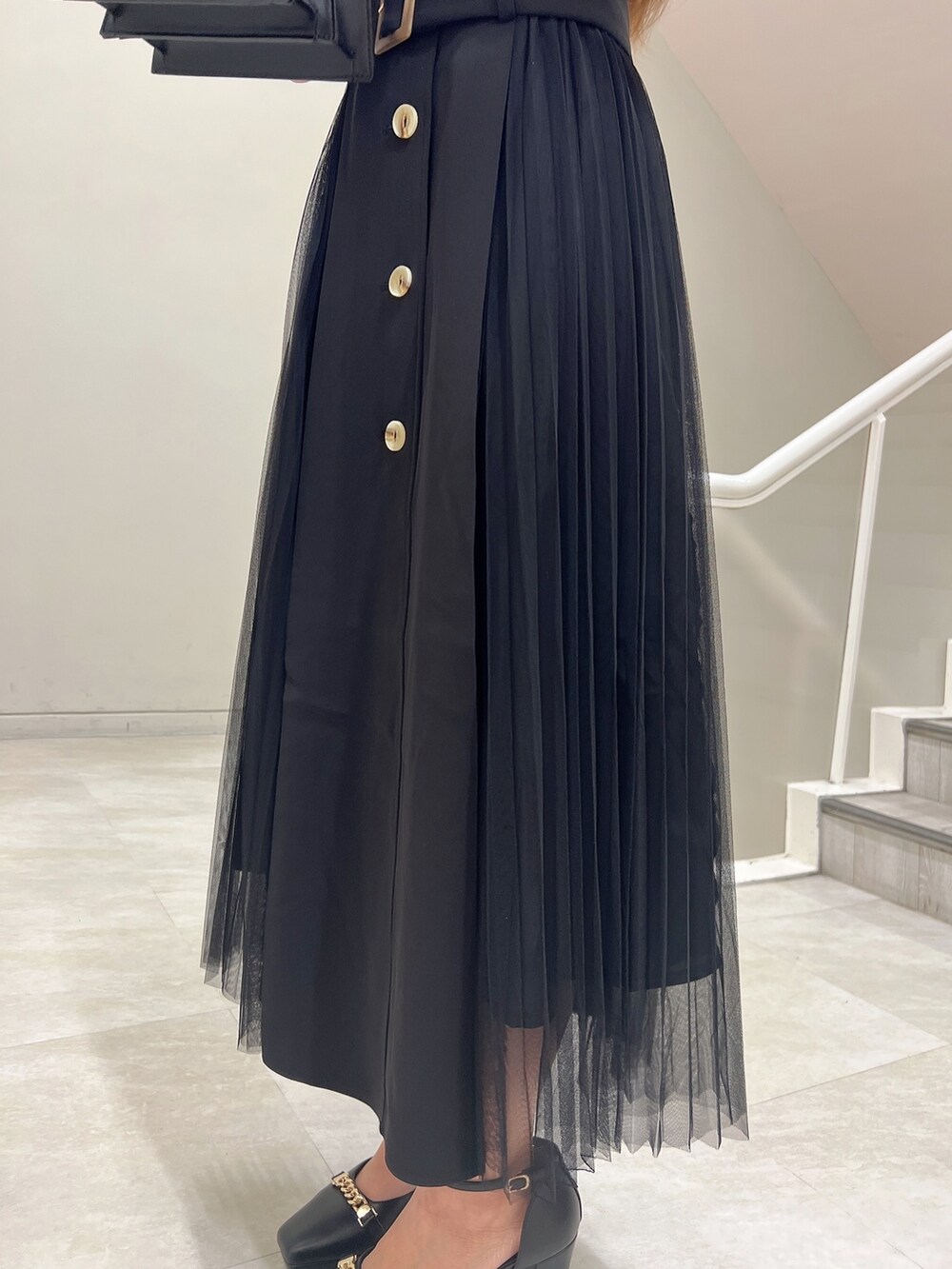 ブラック系のハンドバッグ、ブラック系のワンピース、ブラック系のパンプスを着用したレディースの春コーディネートの5枚目の写真