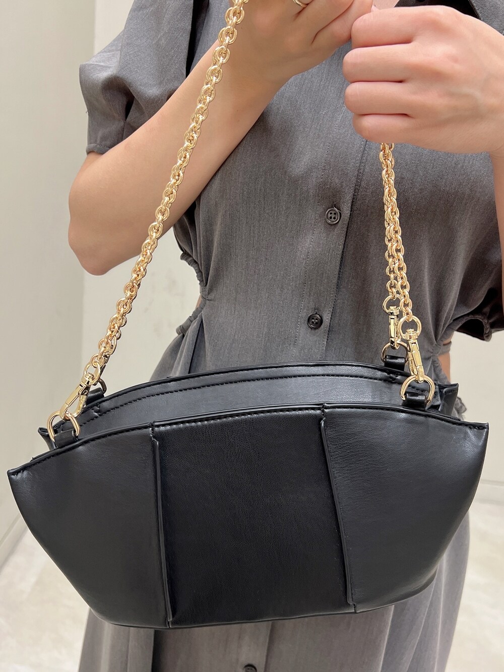 グレー系のワンピース、ブラック系のパンプス、ブラック系のハンドバッグを着用したレディースの春コーディネートの7枚目の写真