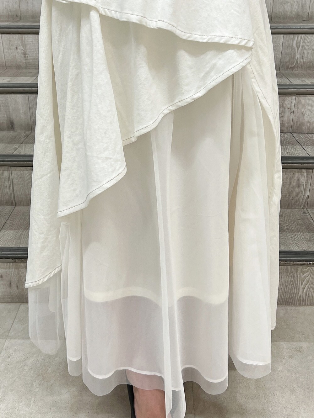 ブラック系のシャツ/ブラウス、ホワイト系のデニムスカート、ブラック系のパンプスを着用したレディースの春コーディネートの7枚目の写真