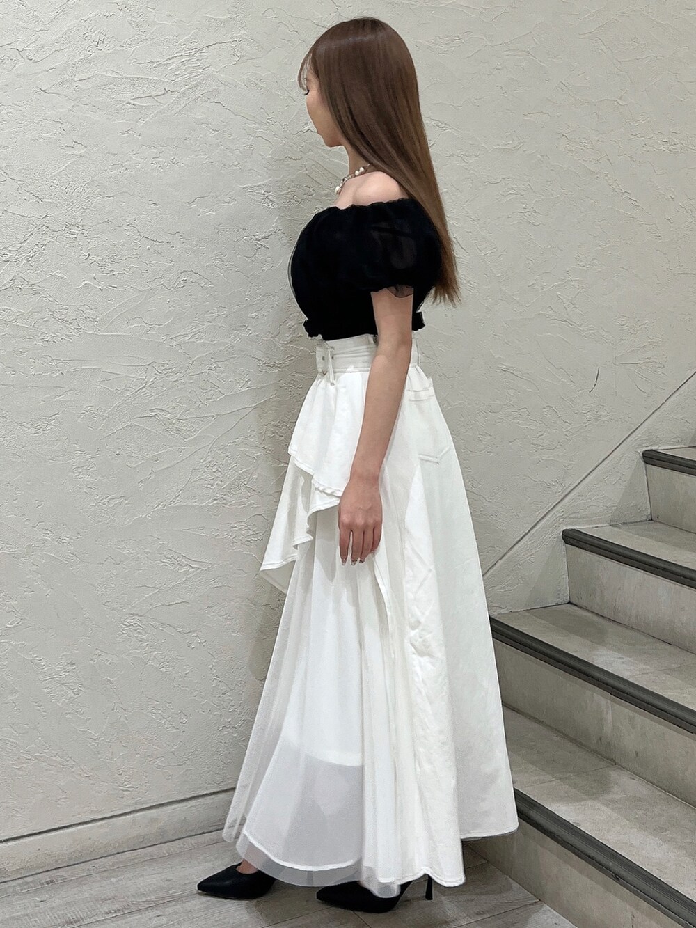 ブラック系のシャツ/ブラウス、ホワイト系のデニムスカート、ブラック系のパンプスを着用したレディースの春コーディネートの3枚目の写真