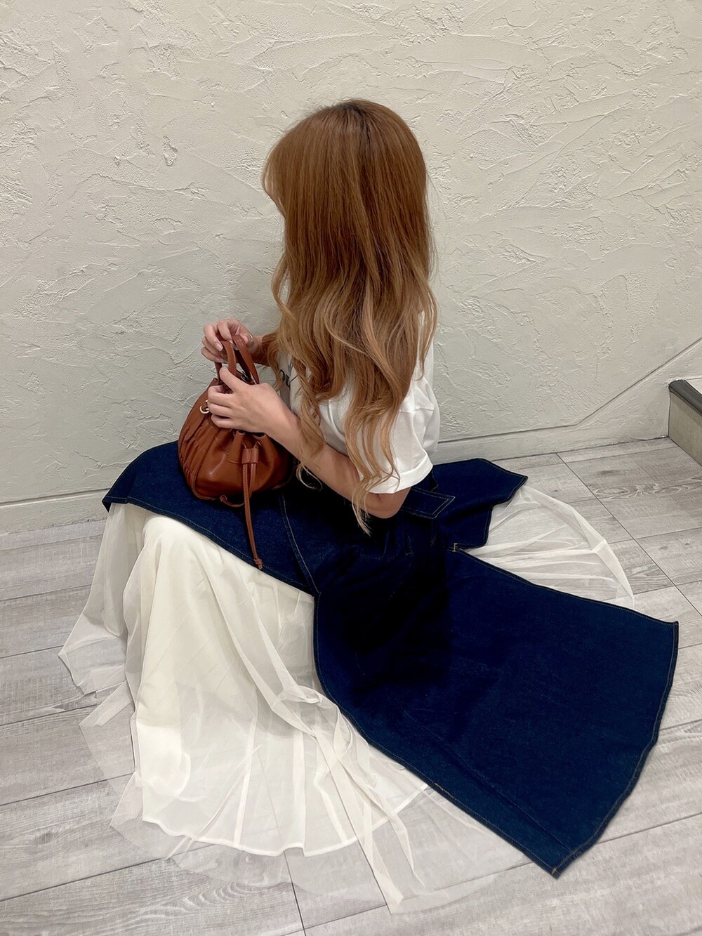 ホワイト系のTシャツ/カットソー、ブラウン系のハンドバッグ、ホワイト系のサンダルを着用したレディースの夏コーディネートの2枚目の写真