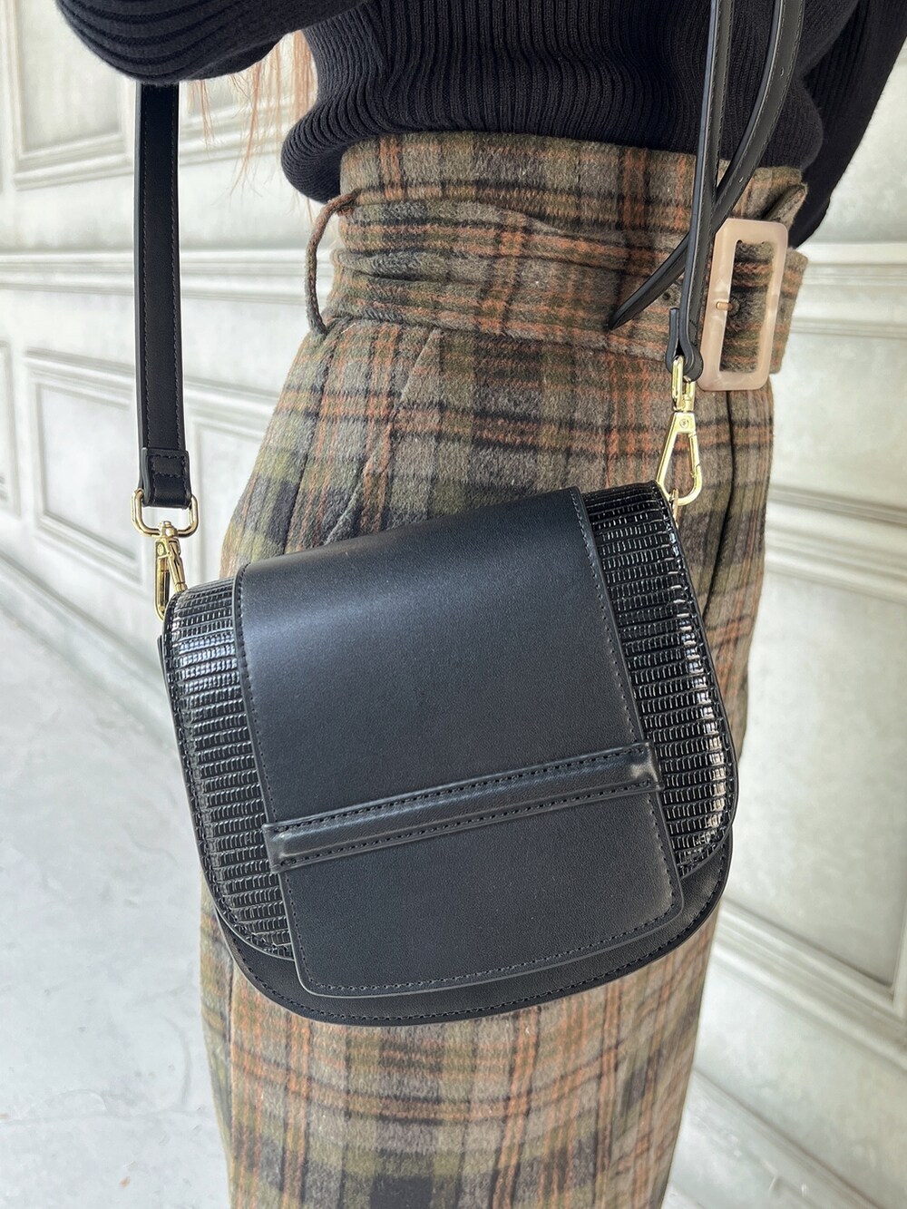 ブラック系のニット/セーター、グリーン系のスカート、ブラック系のショルダーバッグを着用したレディースの秋コーディネートの6枚目の写真