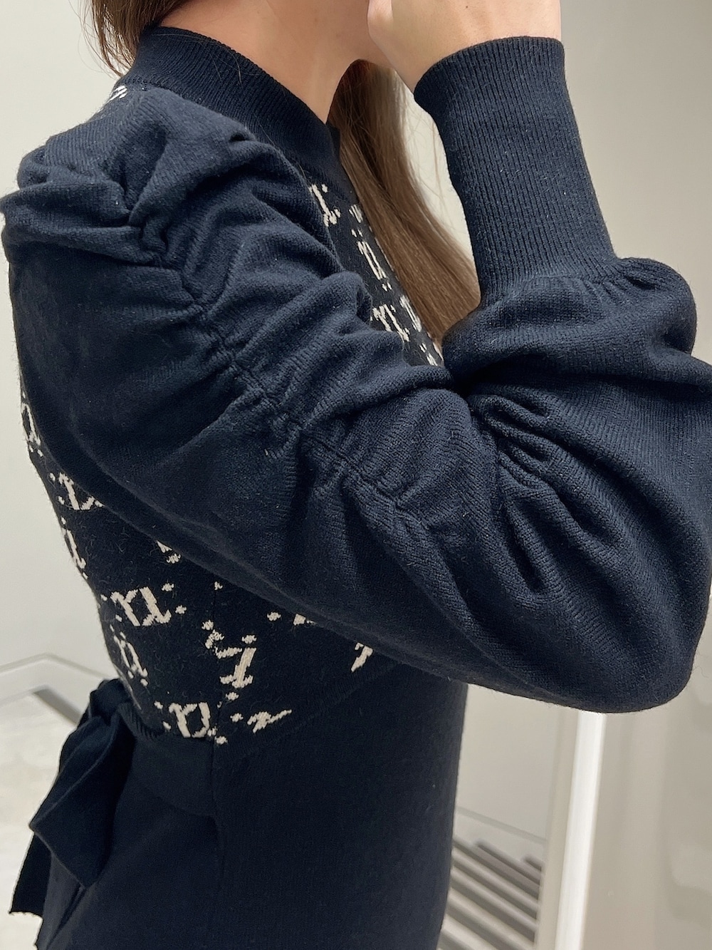 ブラック系のワンピース、ブラック系のショルダーバッグ、ブラック系のパンプスを着用したレディースの冬コーディネートの4枚目の写真