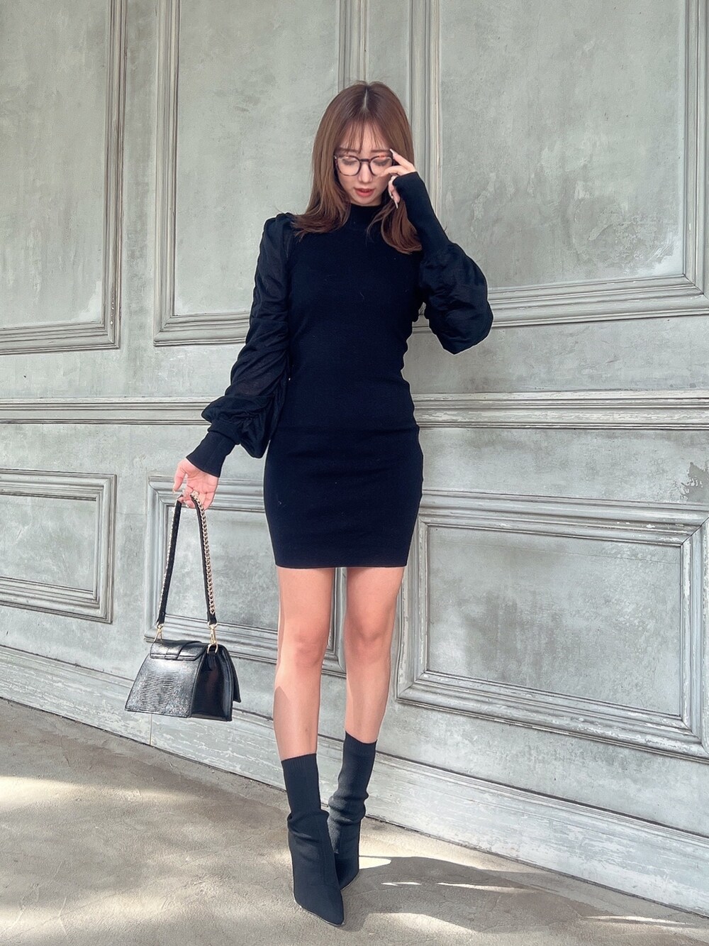 ブラック系のワンピース、ブラック系のハンドバッグ、ブラック系のブーツを着用したレディースの秋コーディネートの3枚目の写真