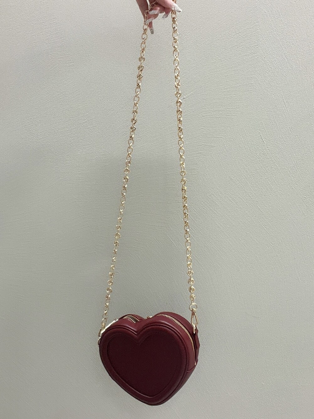 レッド系のショルダーバッグ、ブラック系のワンピース、ブラック系のサンダルを着用したレディースの夏コーディネートの6枚目の写真