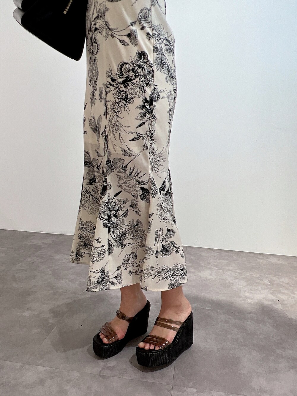 ブラック系のワンピース、ブラック系のサンダル、ブラック系のハンドバッグを着用したレディースの冬コーディネートの7枚目の写真