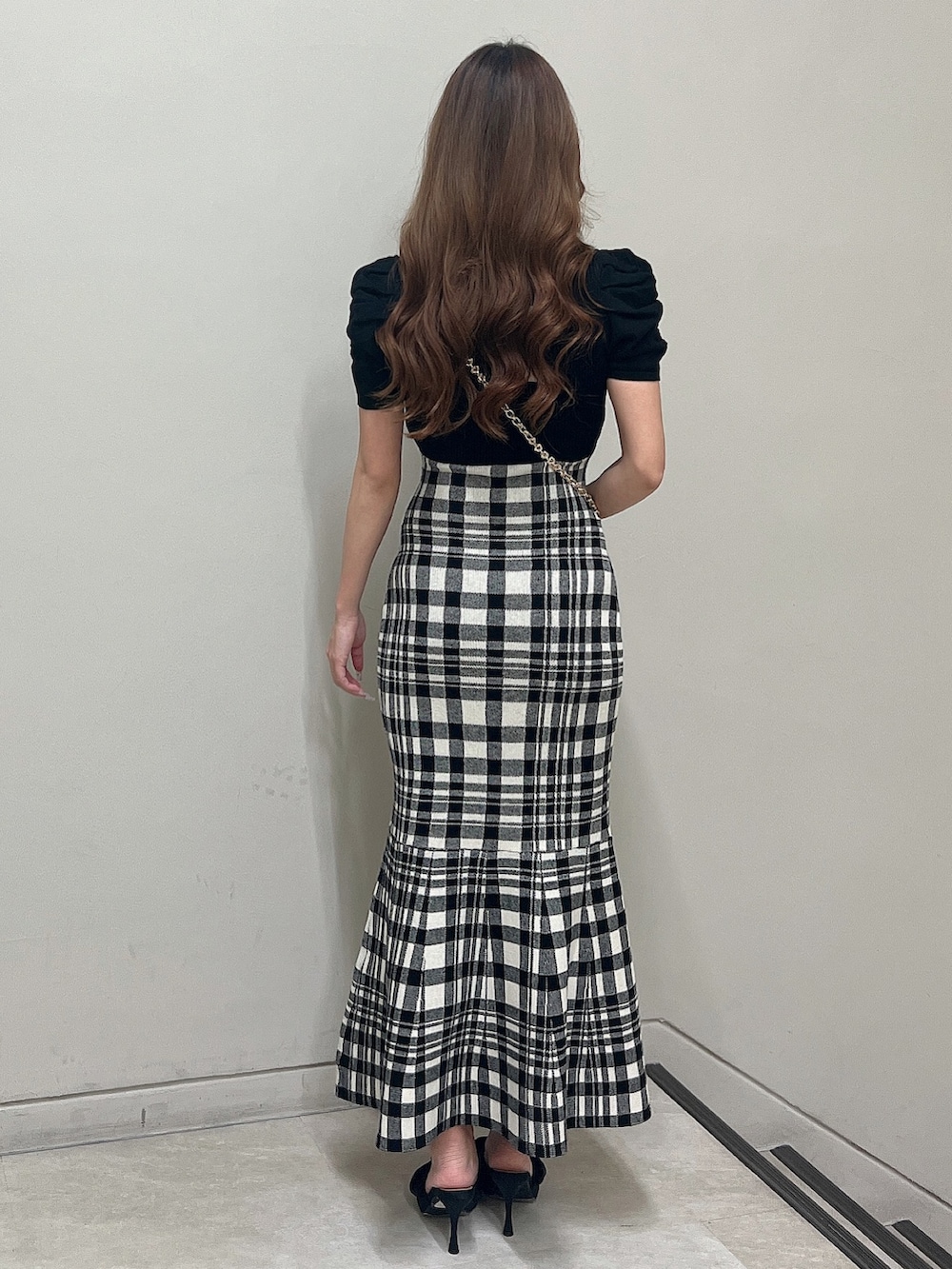 レッド系のショルダーバッグ、ブラック系のワンピース、ブラック系のサンダルを着用したレディースの夏コーディネートの4枚目の写真