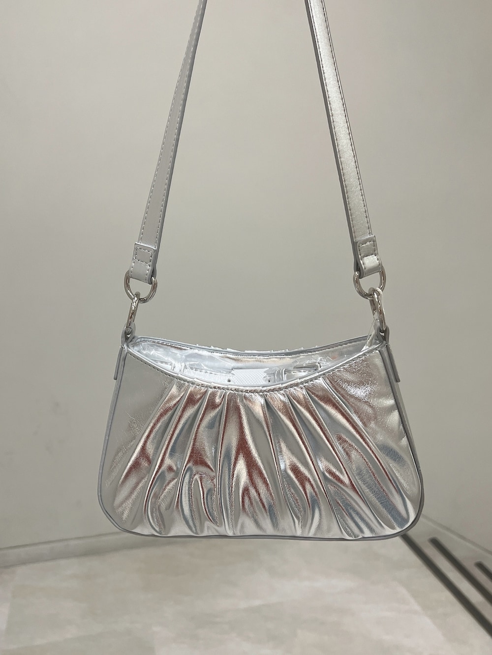 ホワイト系のキャミソール、ブルー系のデニムパンツ、シルバー系のハンドバッグを着用したレディースの春コーディネートの9枚目の写真