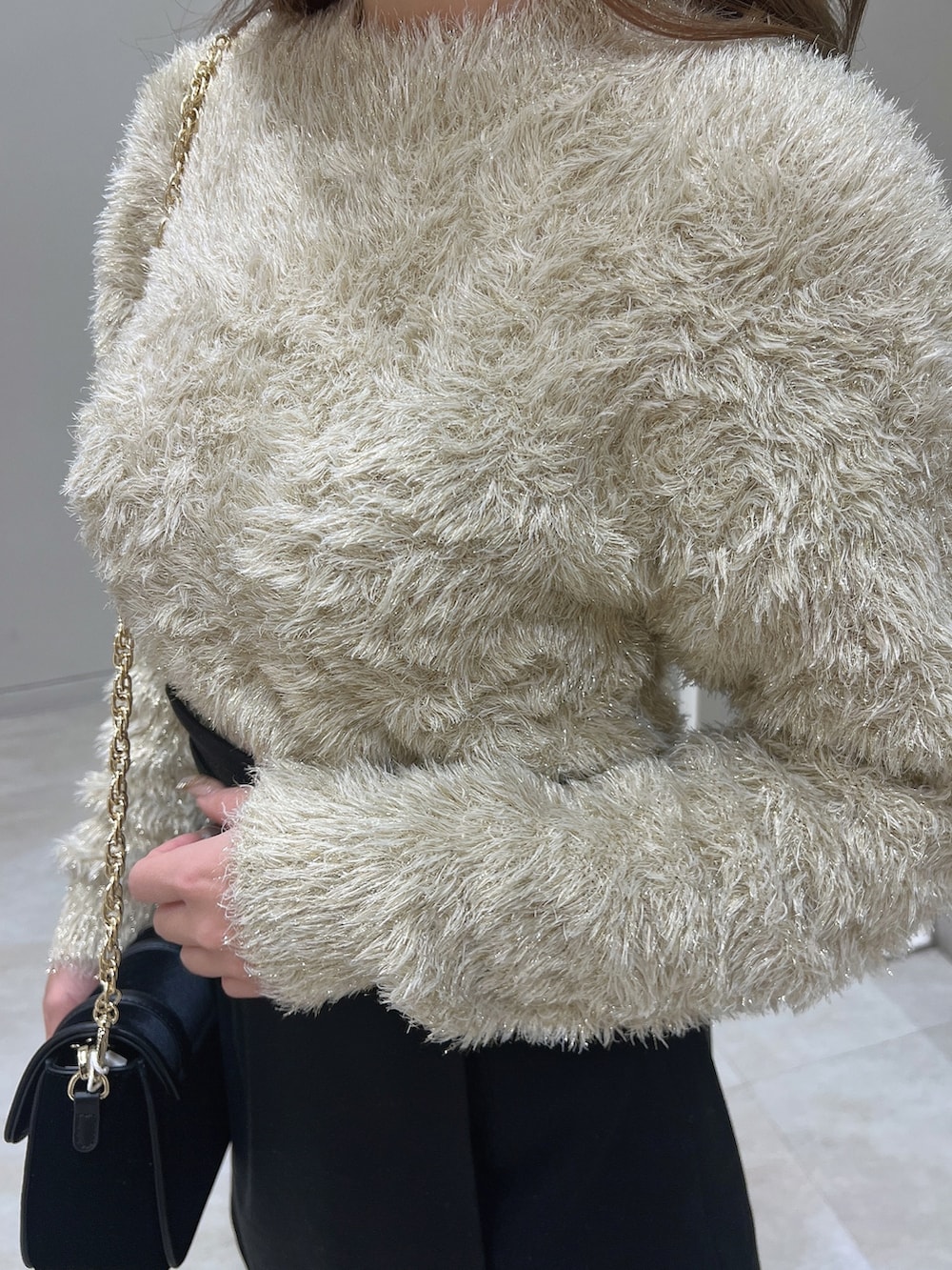 ブラック系のショルダーバッグ、ブラック系のブーツ、ベージュ系のニット/セーターを着用したレディースの冬コーディネートの5枚目の写真