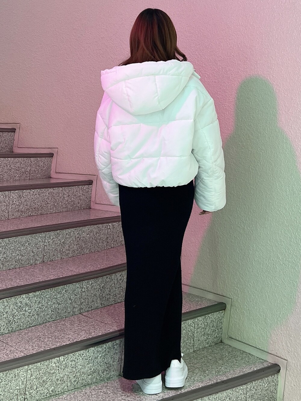 ブラック系のワンピース、ホワイト系のブルゾン、ホワイト系のスニーカーを着用したレディースの冬コーディネートの3枚目の写真