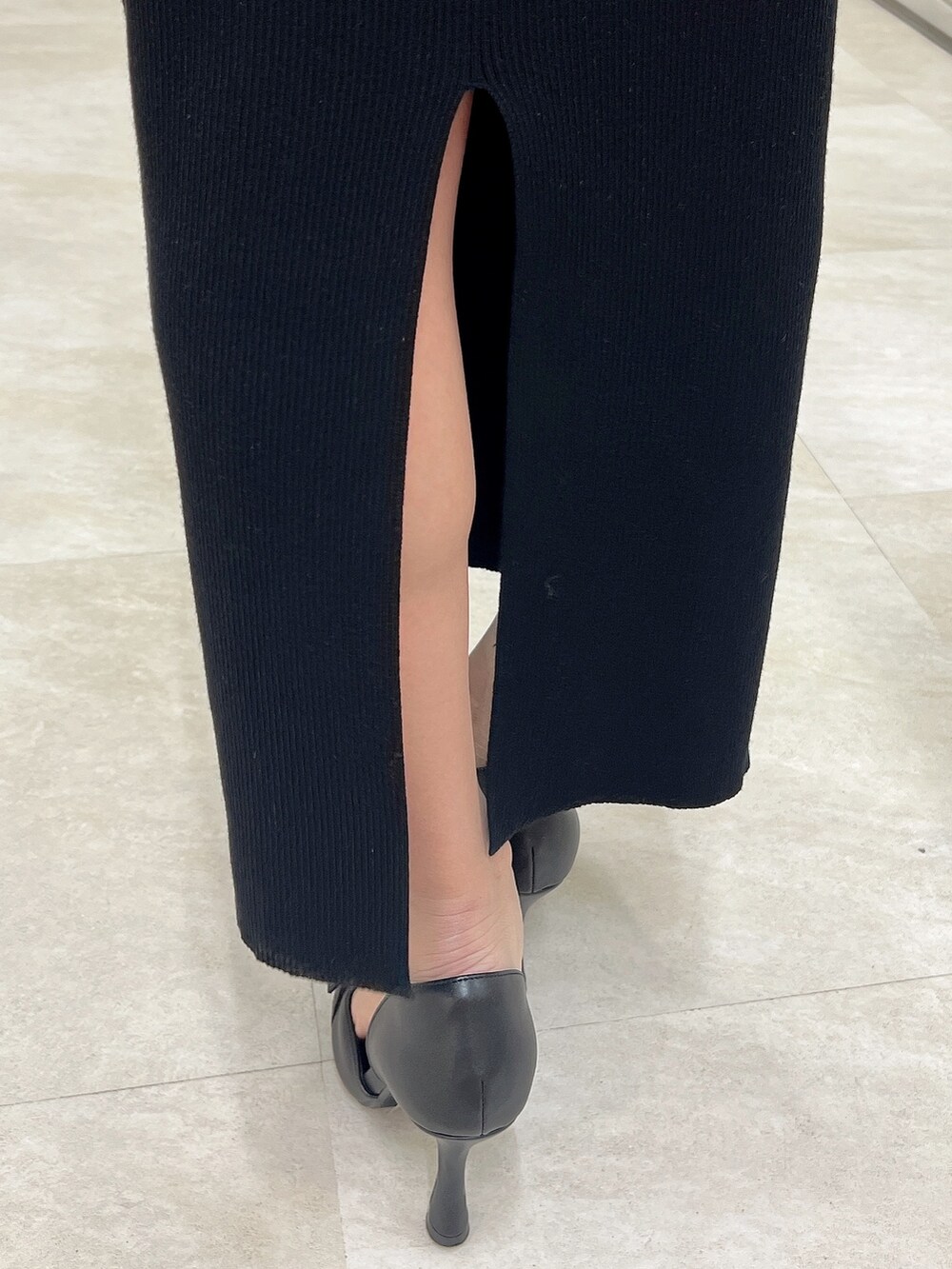 ブラック系のハンドバッグ、ホワイト系のワンピース、ブラック系のパンプスを着用したレディースの春コーディネートの6枚目の写真