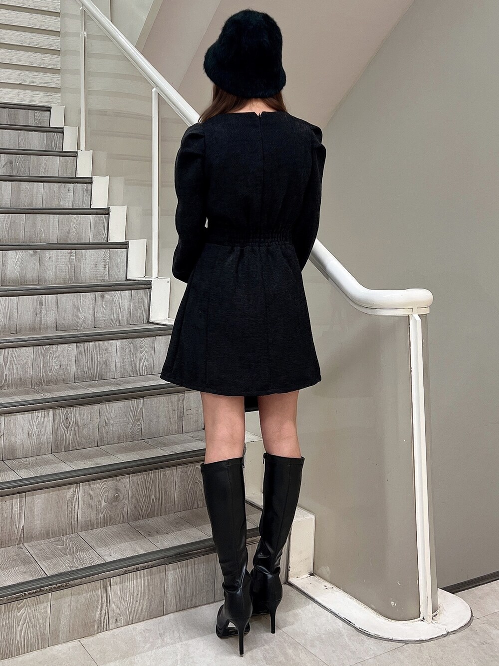 ブラック系のブーツ、ブラック系のハンドバッグ、ブラック系のワンピースを着用したレディースの秋コーディネートの4枚目の写真